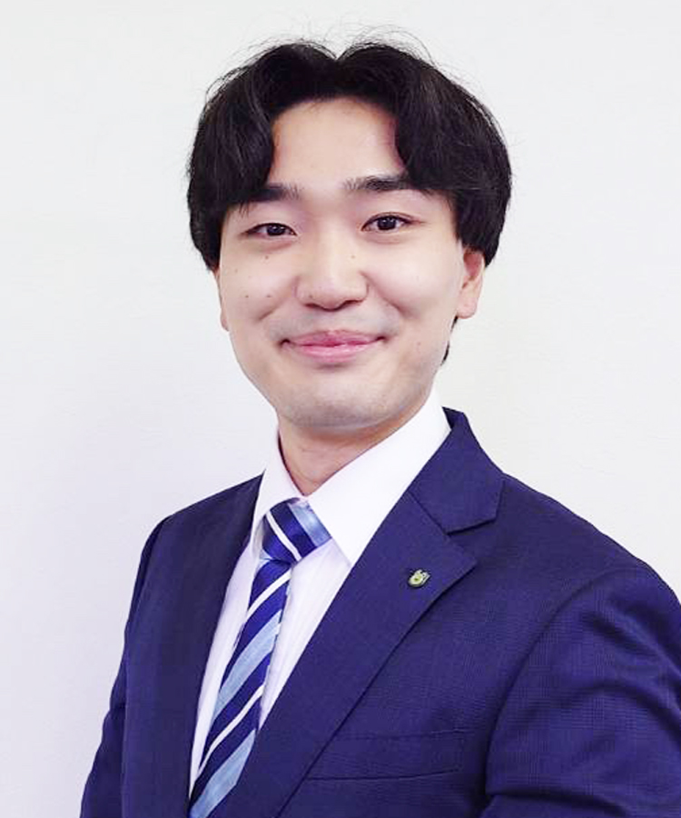 伊藤優汰 | ホームセレクト Professional headshot: man in a navy suit and striped tie, smiling at the camera against a plain background.